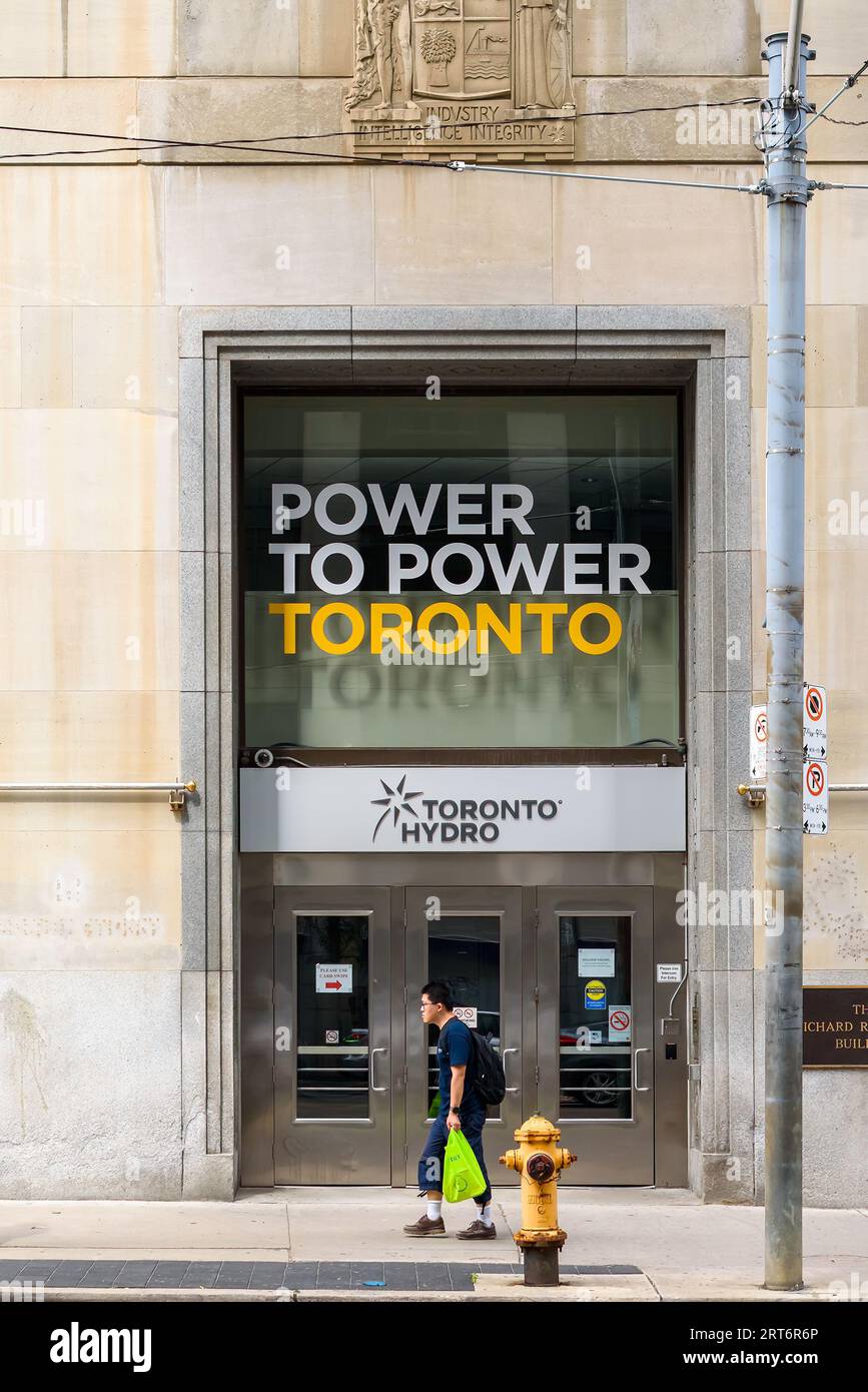 Toronto, Kanada, Eine Person geht am Toronto Hydro Gebäude vorbei. Ein Text lautet Power to Power Toronto Stockfoto