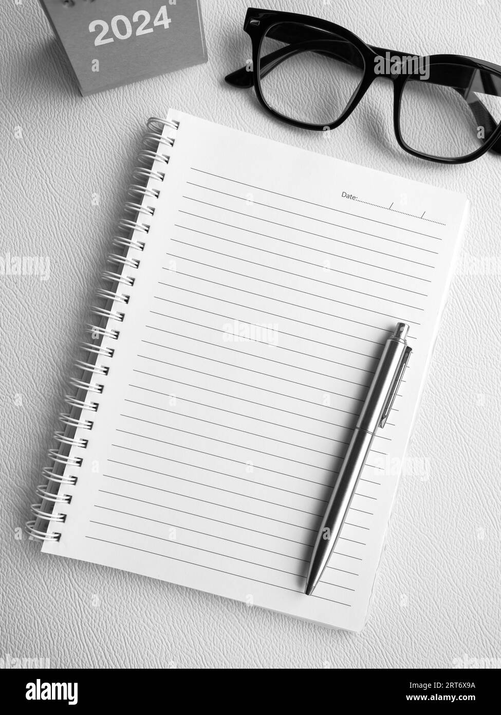 To-do-Liste, Ziele und Zielkonzept im neuen Jahr 2024. Mockup-Vorlage, weißer Leerraum auf spiralförmigem Notizbuch mit Stift und 2024-jährigem Schreibtischkalender Stockfoto