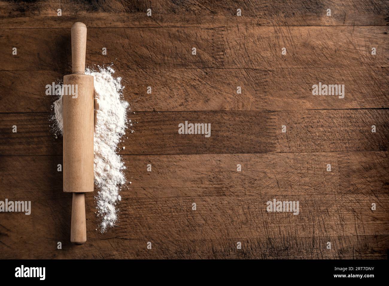 Rollnadel und Mehl auf Holzschneidebrett oder Küchentisch, Draufsicht, Kopierraum. Backen- oder Kochkonzept. Stockfoto