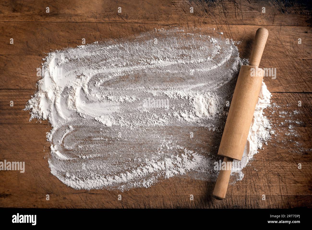Rollnadel und Mehl als Hintergrund auf Holzschneidebrett oder Küchentisch, Draufsicht, Kopierraum. Backen- oder Kochkonzept. Stockfoto