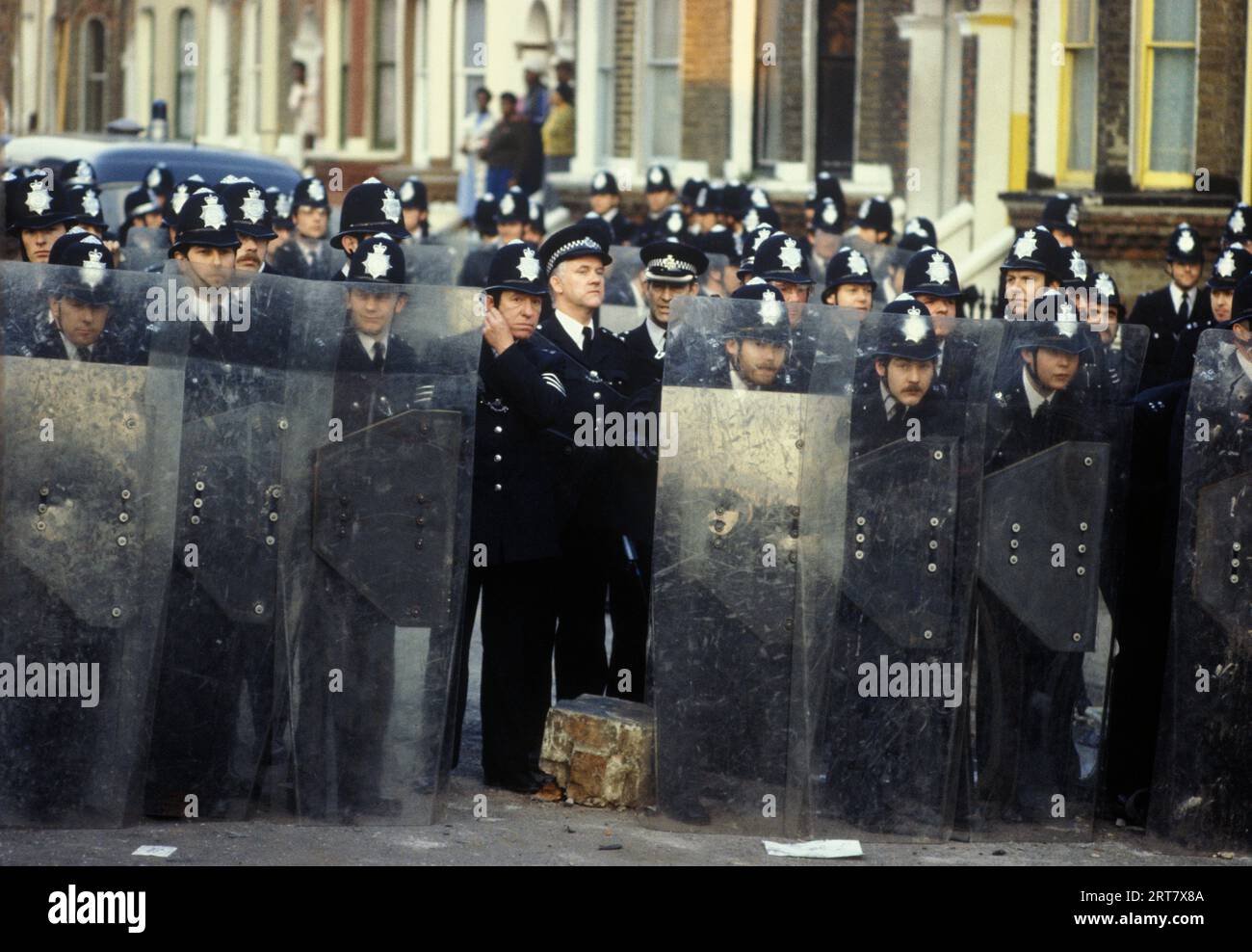 Brixton stößt in den 1980er Jahren auf Großbritannien auf. Polizeibeamte hinter Schilden gruppieren sich auf der Straße. Sie werden langsam mehr vorwärts gehen, um die Randalierer zu zerstreuen. Brixton South London April 1981 England HOMER SYKES. Stockfoto