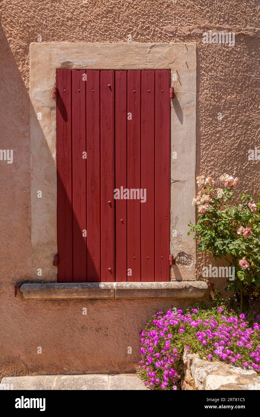 Fenster mit roten geschlossenen Fensterläden, Roussillon, Luberon, Departement Vaucluse, Provence-Alpes-Cote dAzur, Frankreich Stockfoto