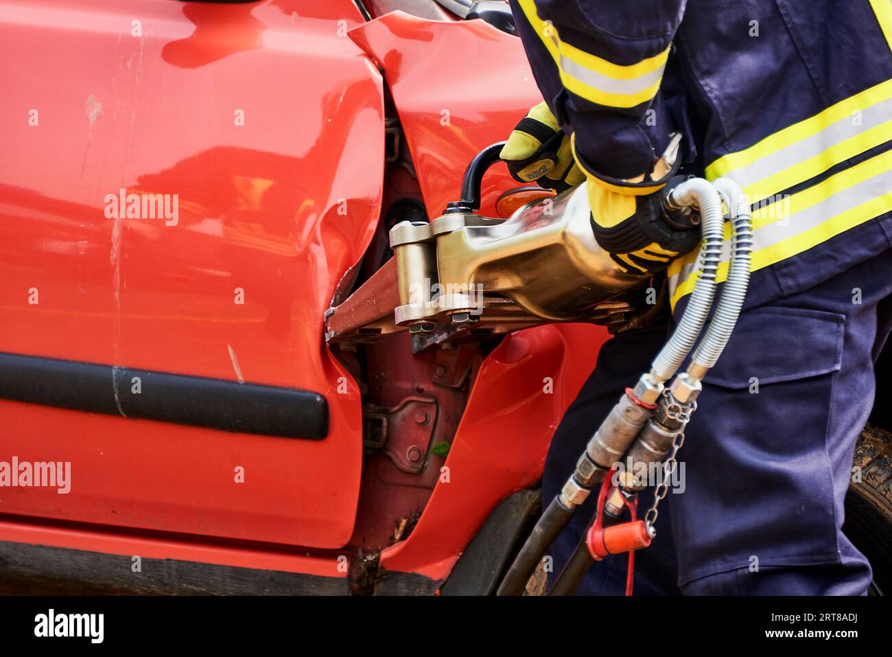 Der Feuerwehrmann befreit die Einsatzgebiete des Autounfalls Stockfoto