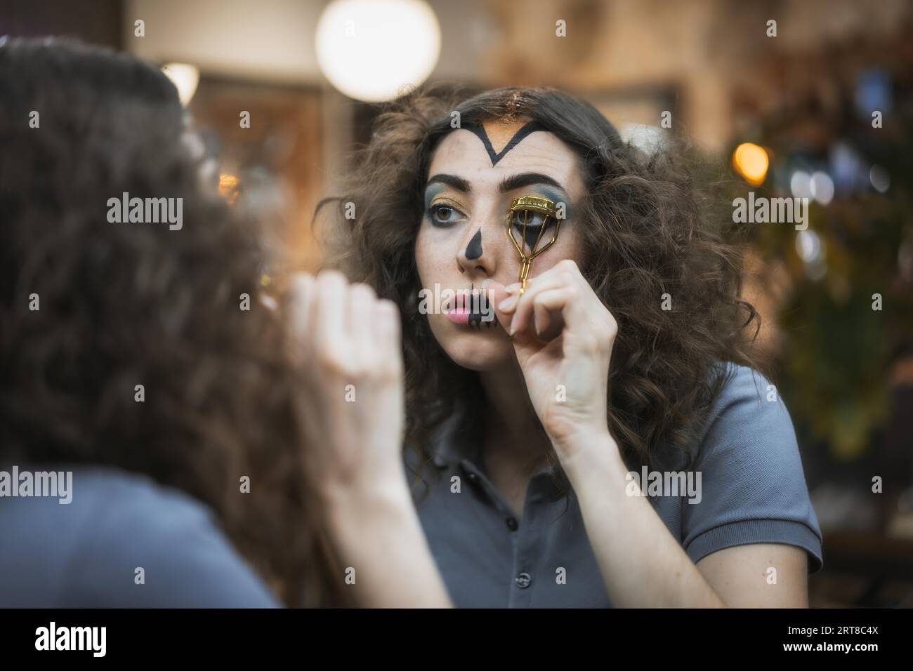Haar- und Make-up-Vorbereitungen für die Halloween-Party, Frau, die mit einem Werkzeug ihre Wimpern anzieht Stockfoto