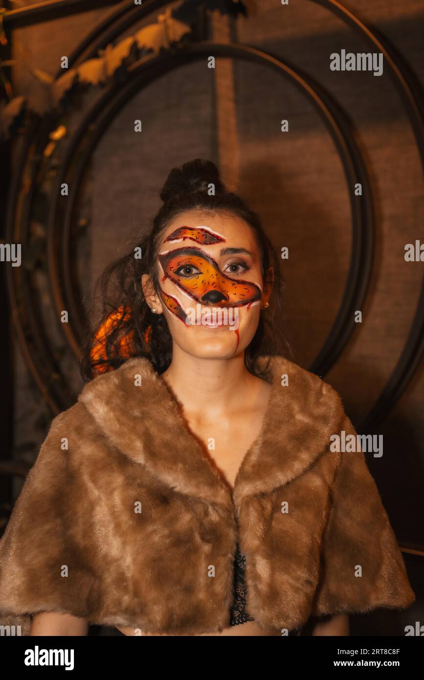 Halloween-Party mit Freunden in einem Disco-Nachtclub, Porträt einer Frau mit einem bemalten Gesicht mit roten Wunden Stockfoto