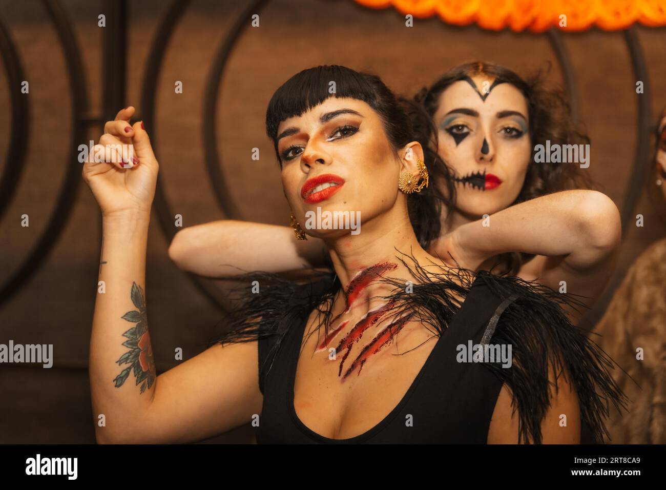 Freundinnen in Kostümen auf der halloween-Party mit Freunden in einem Disco-Nachtclub Stockfoto