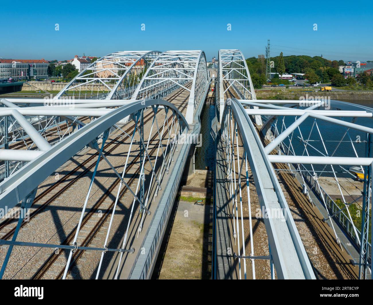 Neue dreifach gebundene Eisenbahnbrücke mit vier Gleisen, Laufsteg und Fahrradroute über die Weichsel in Krakau, Polen. Drohnenansicht aus der Luft Stockfoto