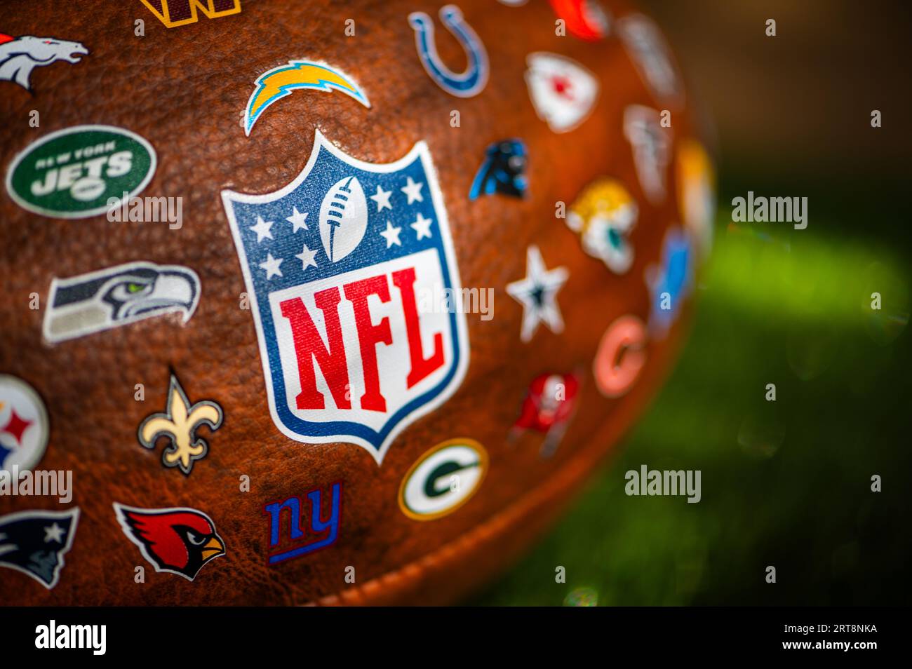 NEW YORK, USA, 11. SEPTEMBER 2023: NFL Game Ball, Logo im Fokus und Logos aller anderen Teams der National Football League Stockfoto