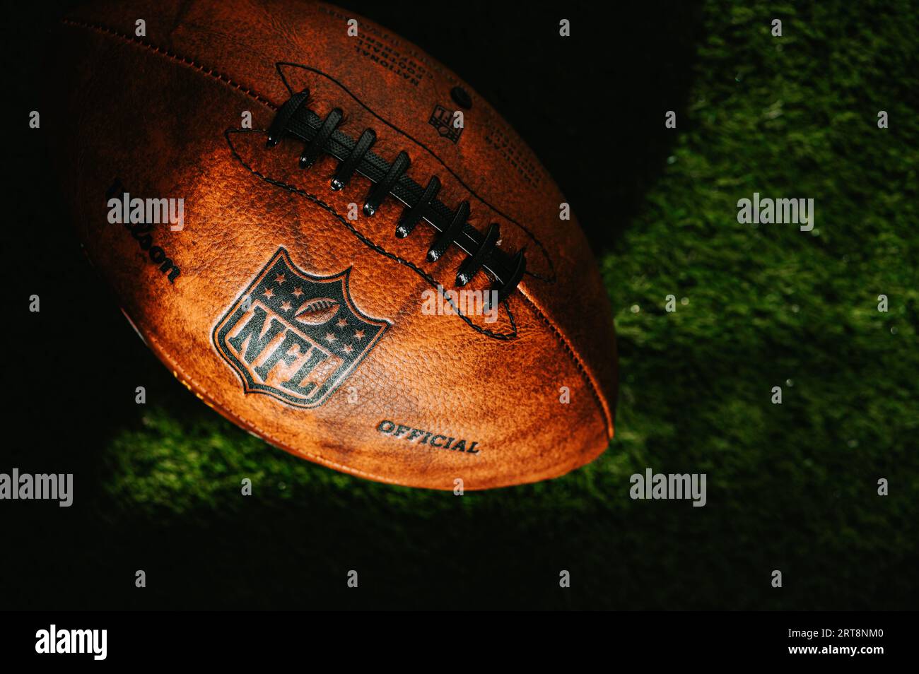 NEW YORK, USA, 11. SEPTEMBER 2023: Detailansicht des NFL-Lederballs auf dem grünen Feld, bedeckt von Abendlicht und Schatten. Illustratives Foto, Stockfoto