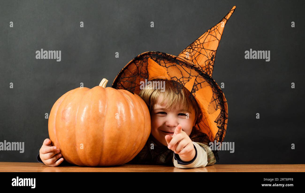 Vorbereitung auf den Halloween-Urlaub. Kleiner Junge mit Hexenhut und Halloween-Kürbis. Trick oder Belohnung. Halloween-Kind mit Jack-o-Laterne-Kürbis Stockfoto
