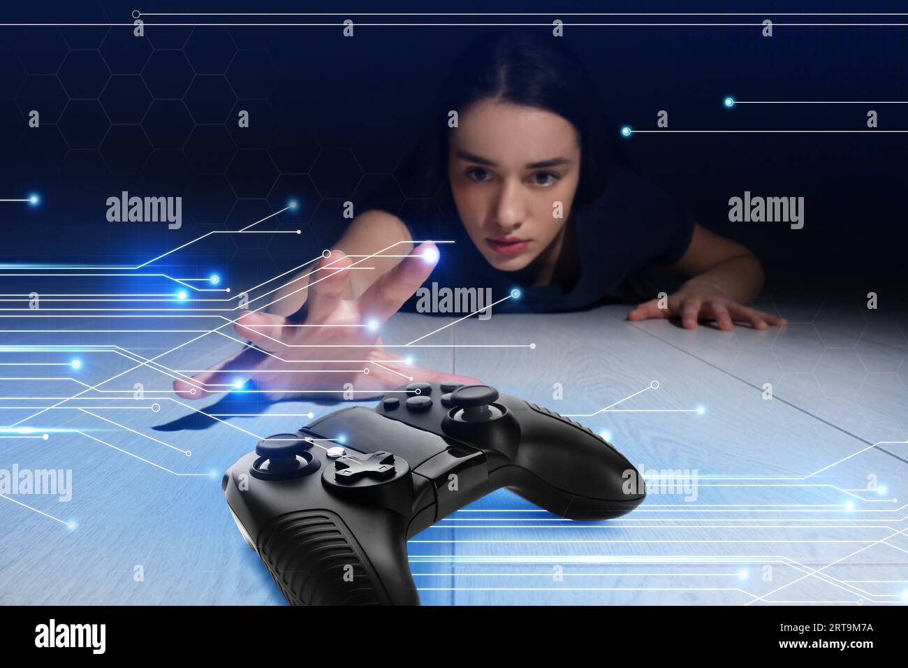 Spielstörung. Frau, die sich vor der Dunkelheit nach Gamepad auf dem Boden streckt. Leiterplattenmuster Stockfoto