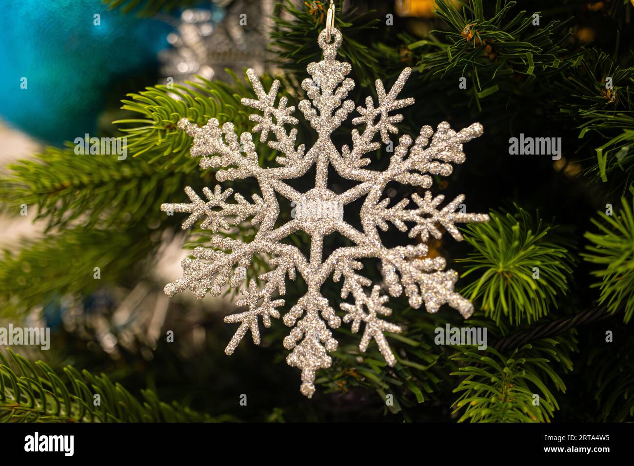 Nahaufnahme einer Weihnachtsdekoration mit Schneeflocke, die an einem Weihnachtsbaum hängt Stockfoto