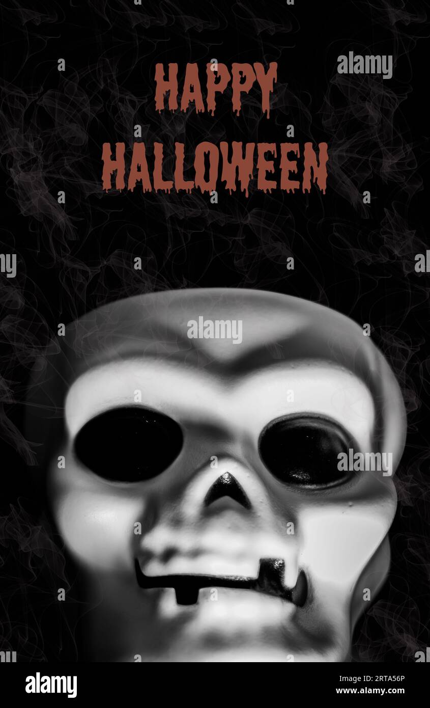 Happy Halloween Schild oder Einladung mit Schädel auf schwarzem Hintergrund mit Rauch. Halloween-Zeichen in orangen Buchstaben. Leerzeichen kopieren Stockfoto