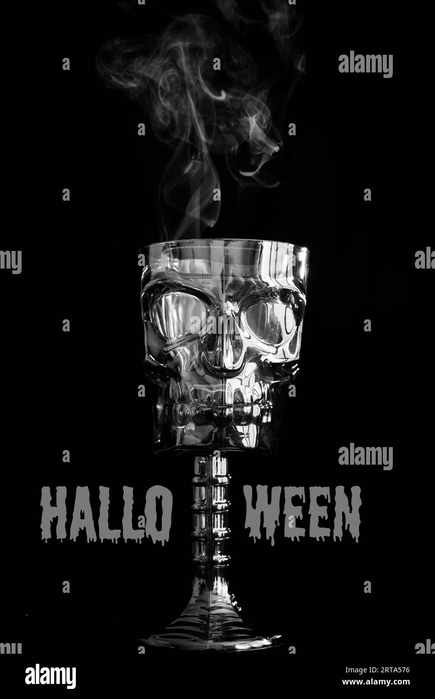 Happy Halloween Party-Schild oder Einladung mit einer dekorativen Schädelschale, rauchend. Halloween-Zeichen in grauen Buchstaben auf schwarzem Hintergrund. Kopieren Stockfoto