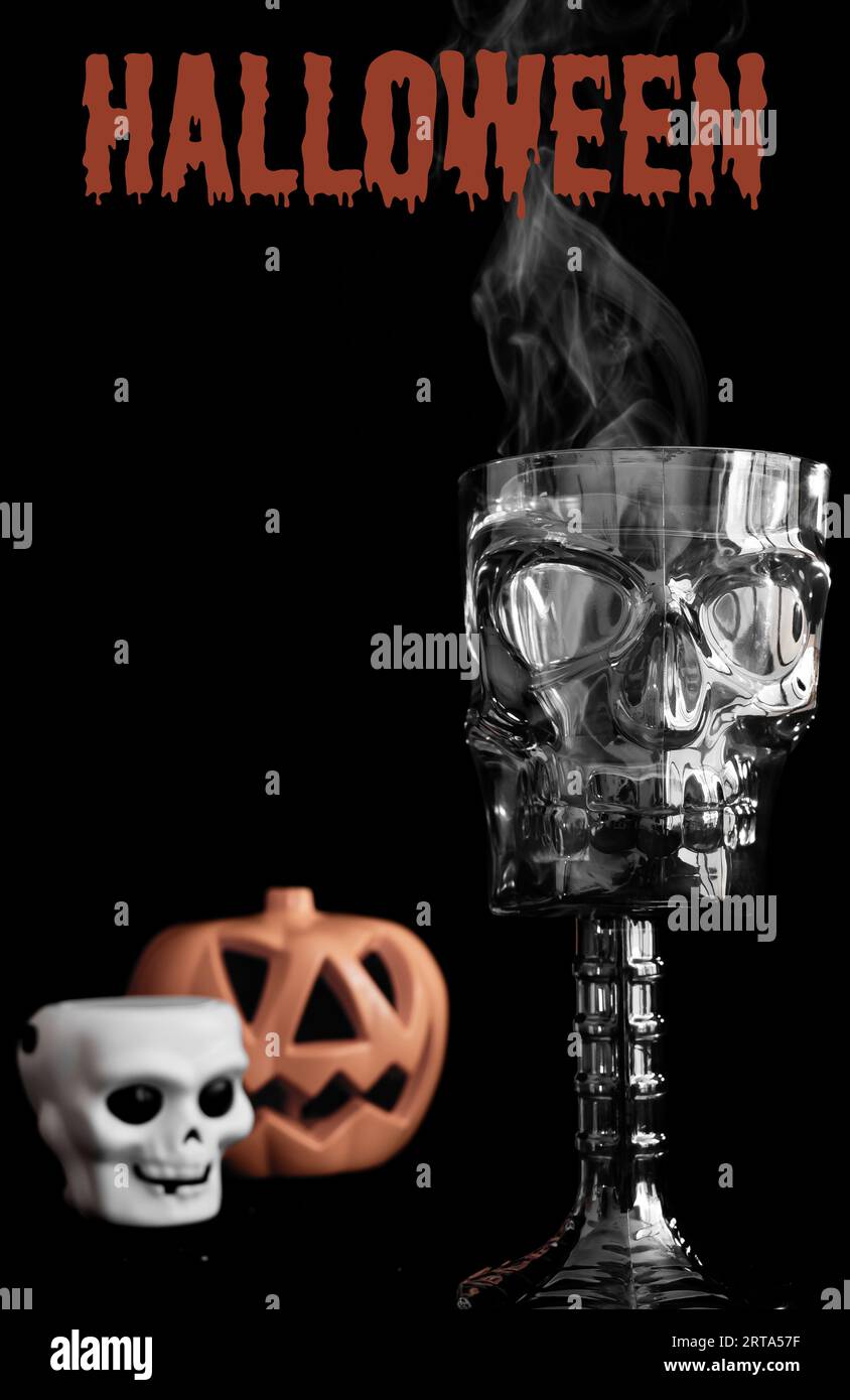 Happy Halloween Party-Schild oder Einladung mit dekorativem, schädelförmigen Becher, rauchend, im Vordergrund. Kürbis und Schädel im Hintergrund. Halloween-Zeichen Stockfoto