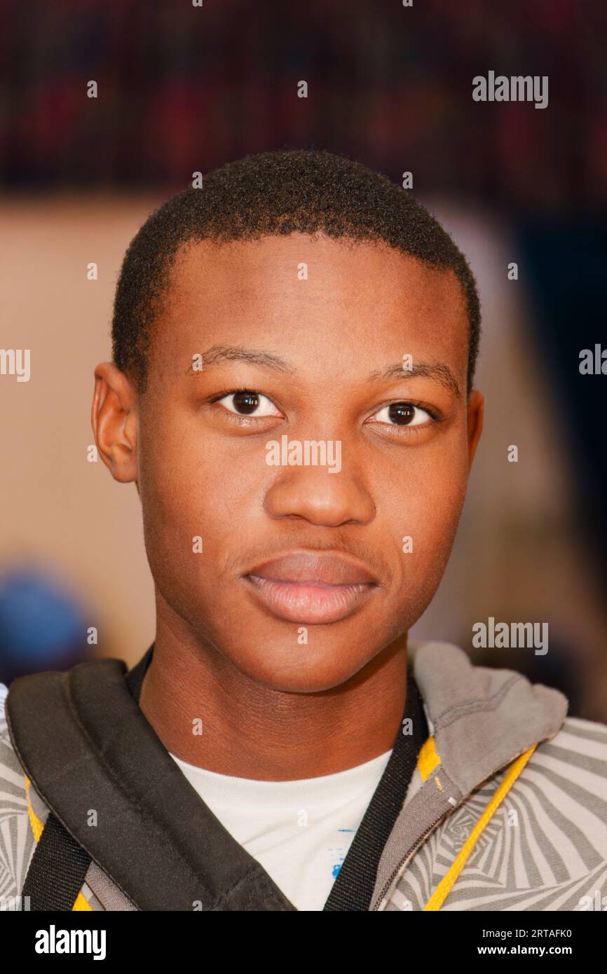 Nahporträt eines jungen afroamerikanischen Mannes, der allein auf den Fluren seiner Universität steht Stockfoto