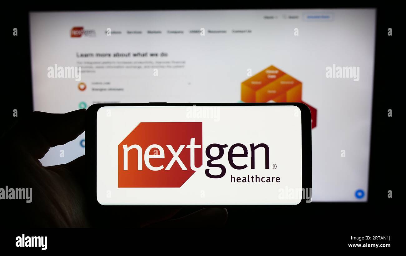 Person, die ein Mobiltelefon mit dem Logo des US-Softwareunternehmens NextGen Healthcare Inc. Auf dem Bildschirm vor der Business-Webseite hält. Konzentrieren Sie sich auf das Display des Telefons. Stockfoto