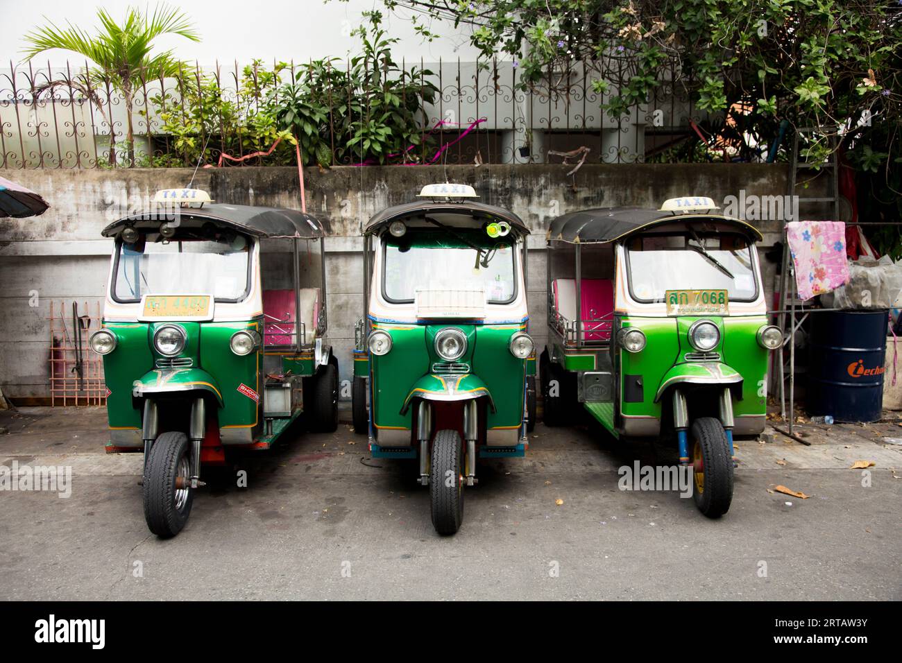Bangkok, Thailand; 1. Januar 2023: Drei Tuk Tuks in einer Reihe auf einer Stadtstraße. Stockfoto