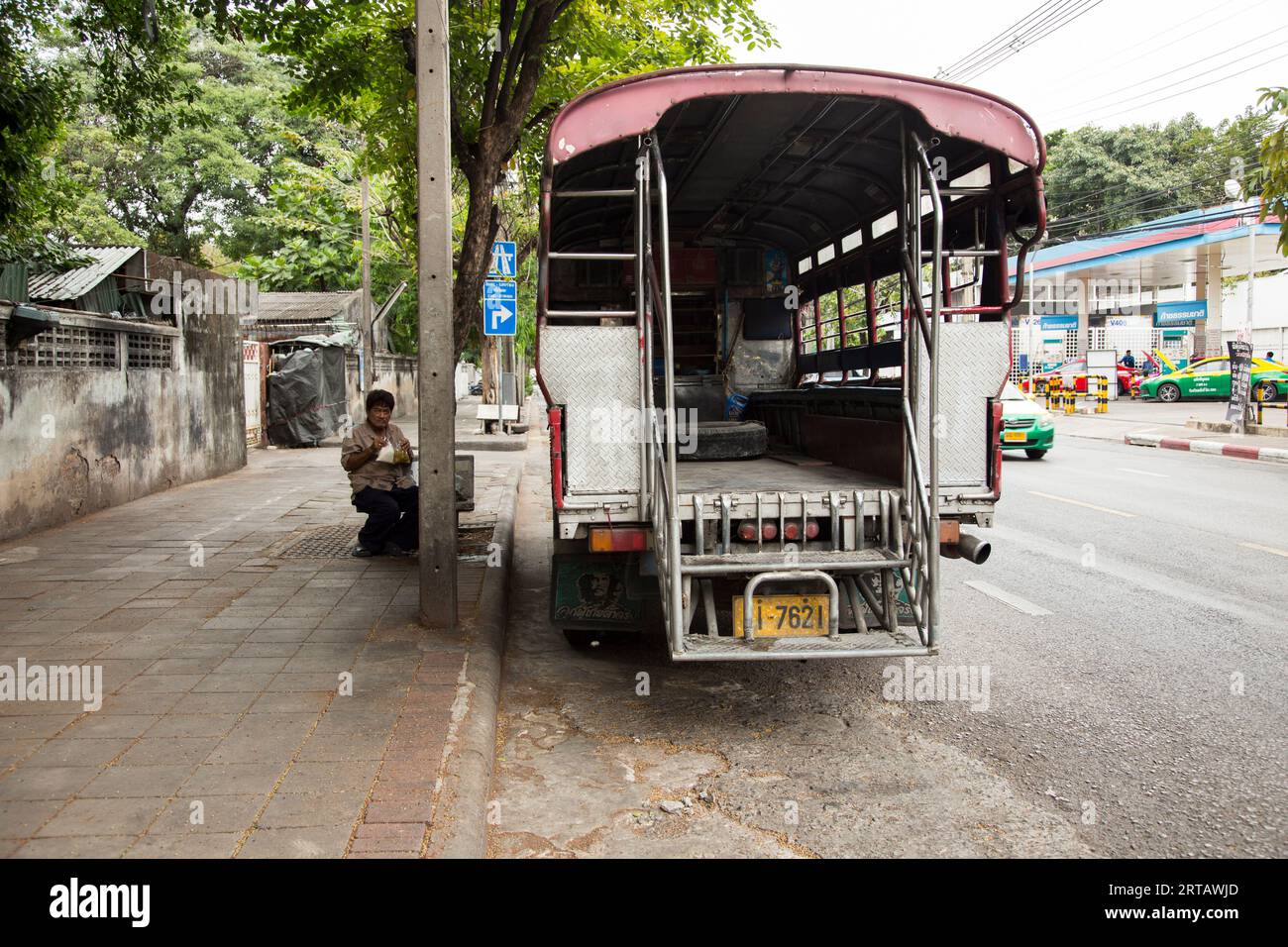 Bangkok, Thailand; 1. Januar 2023: Mann isst auf der Straße neben einem Van in Bangkok. Stockfoto