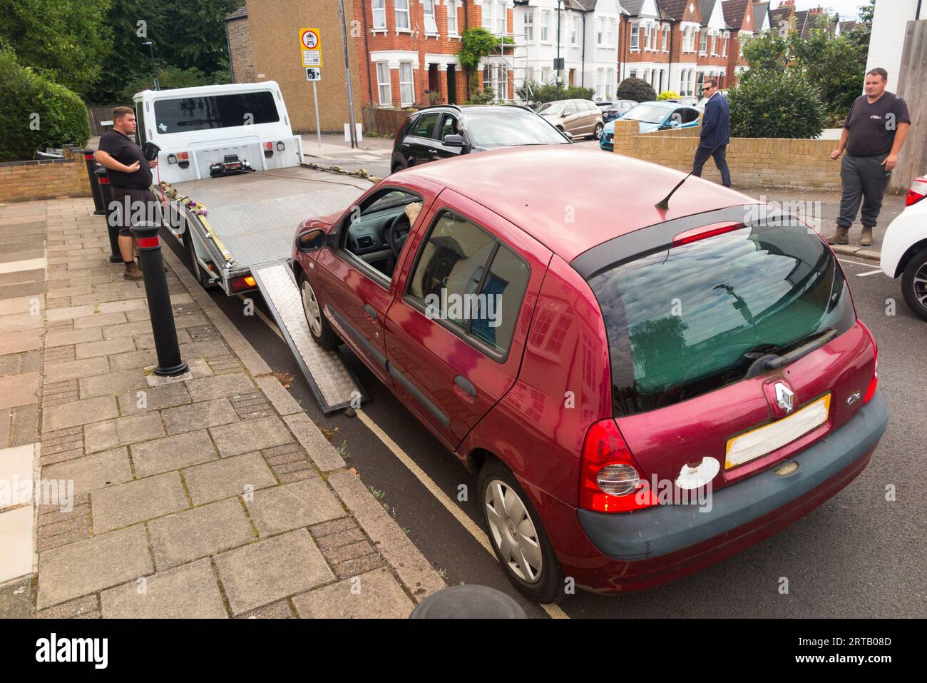 Ein Renault Clio Diesel aus dem Jahr 2003 wird von der Schrottfahrzeugfirma weggenommen, da es nicht mit der erweiterten ULEZ (Ultra Low Emission Zone) konform ist, die vom Londoner Bürgermeister Sadiq Khan eingeführt wurde. Der Besitzer, eine dreijährige Mutter, erhält eine Kinderbeihilfe und sollte eine gewisse finanzielle Entschädigung erhalten. (135) Stockfoto