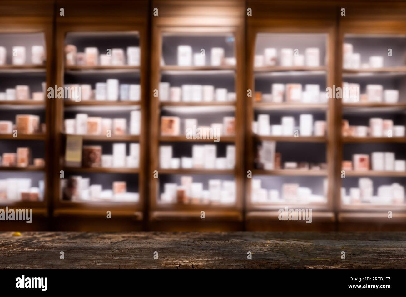 Dunkler Holzzähler mit verschwommenen Apothekenregalen, ideal für Produktpräsentationen oder Modelle. Stockfoto