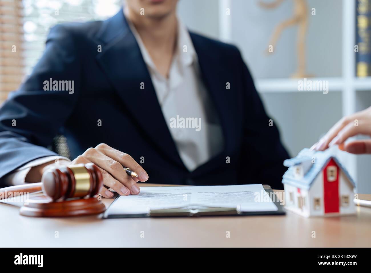 Hauskreditversicherung, männlicher Anwalt oder Richter beraten mit dem Kunden und arbeiten mit Gesetzbüchern Stockfoto