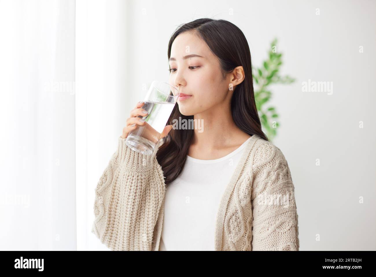 Junge Japanerin, die einen Drink hat Stockfoto