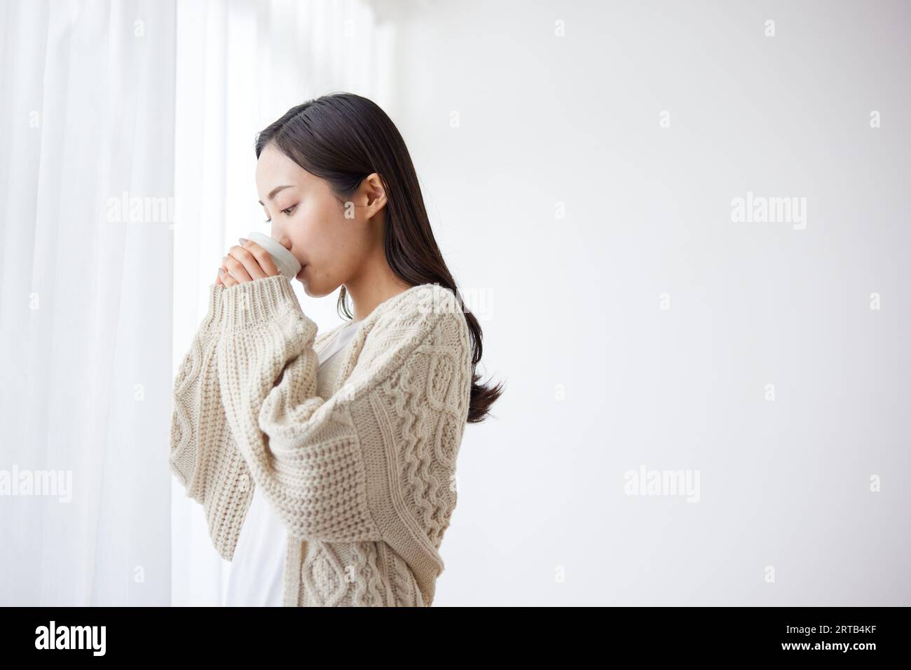 Junge Japanerin, die einen Drink hat Stockfoto