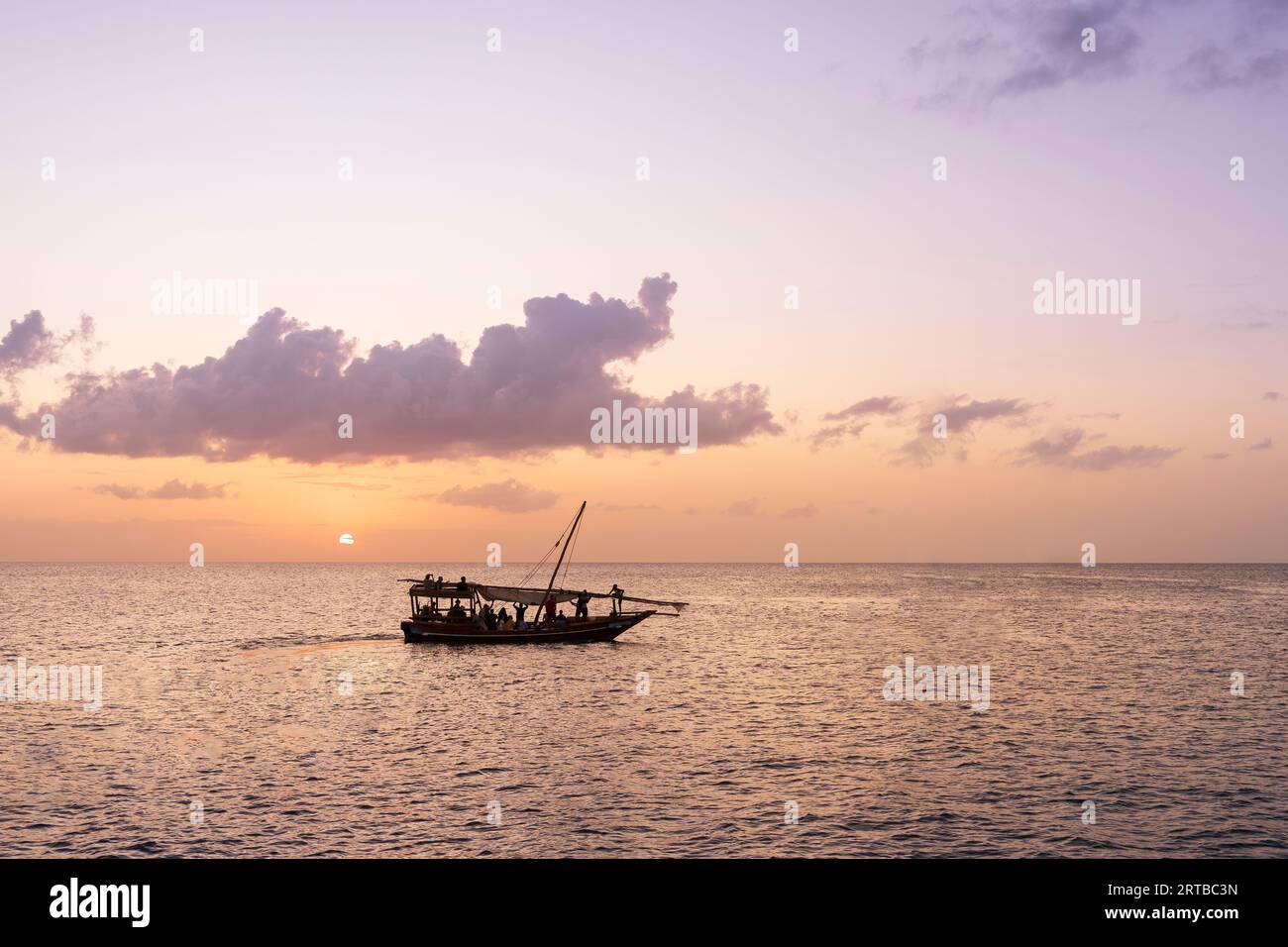 Dhow-Boot bei Sonnenuntergang, Wolken im Hintergrund, Sansibar in Tansania. Stockfoto