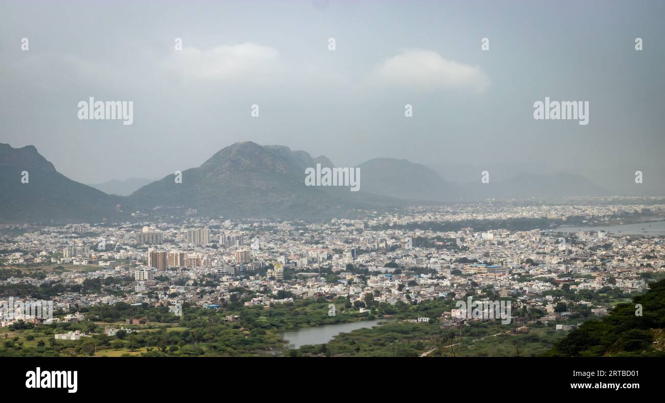 Überfüllte Stadthäuser Landschaft mit nebelnem Berg Hintergrund am Morgen aus flachem Winkel Bild wird in pushkar rajasthan indien aufgenommen Stockfoto