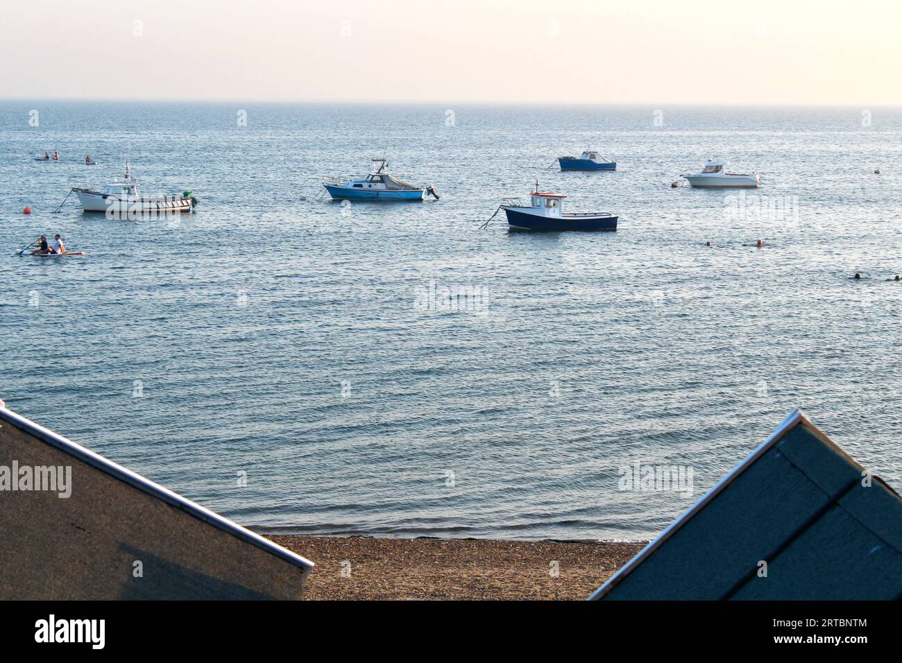 Southend on Sea, Essex, England, Großbritannien - kleine Boote in der Themse und auf den Spitzen der Strandhütten Stockfoto