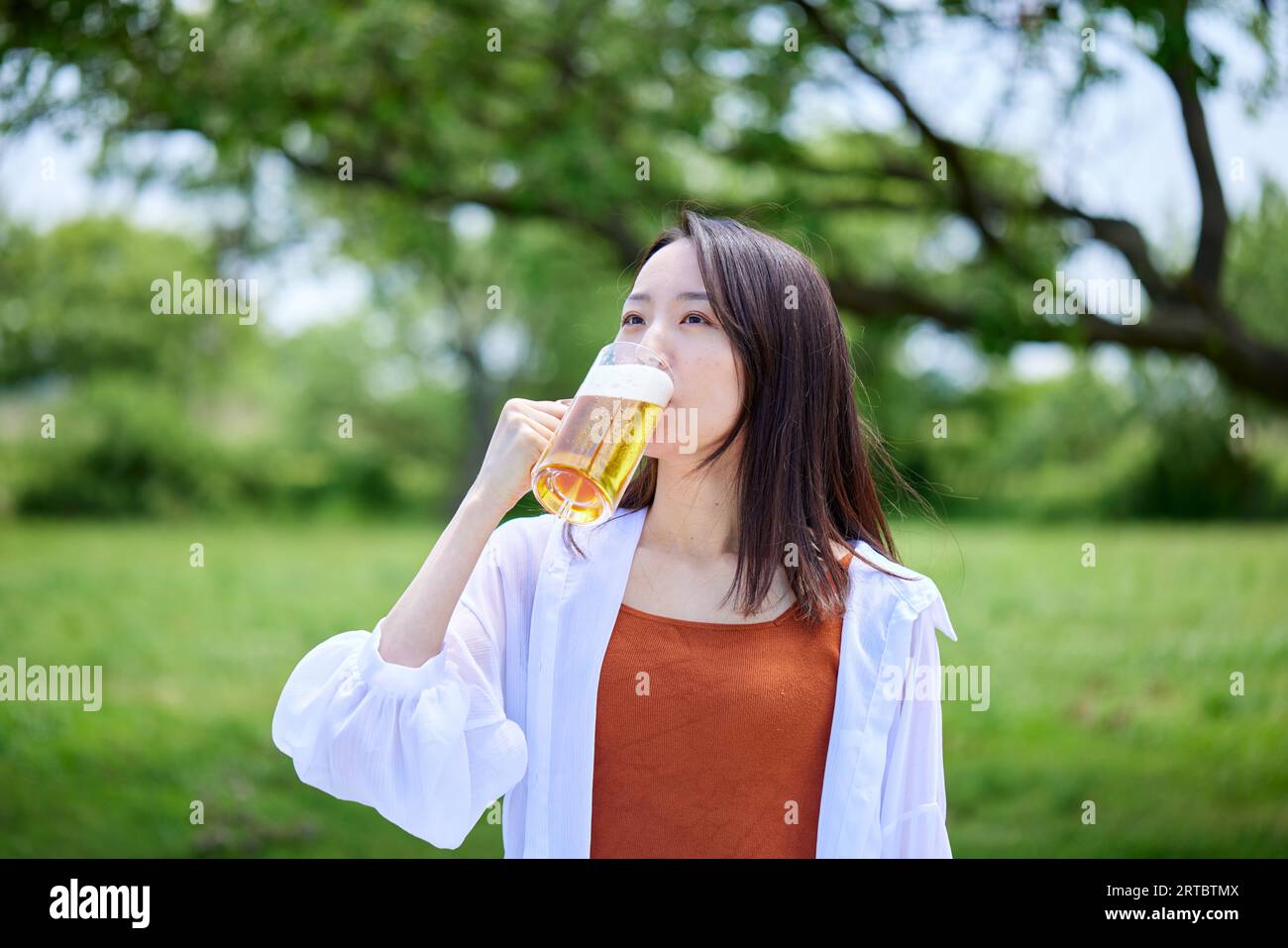 Japanische Frau trinkt Bier Stockfoto