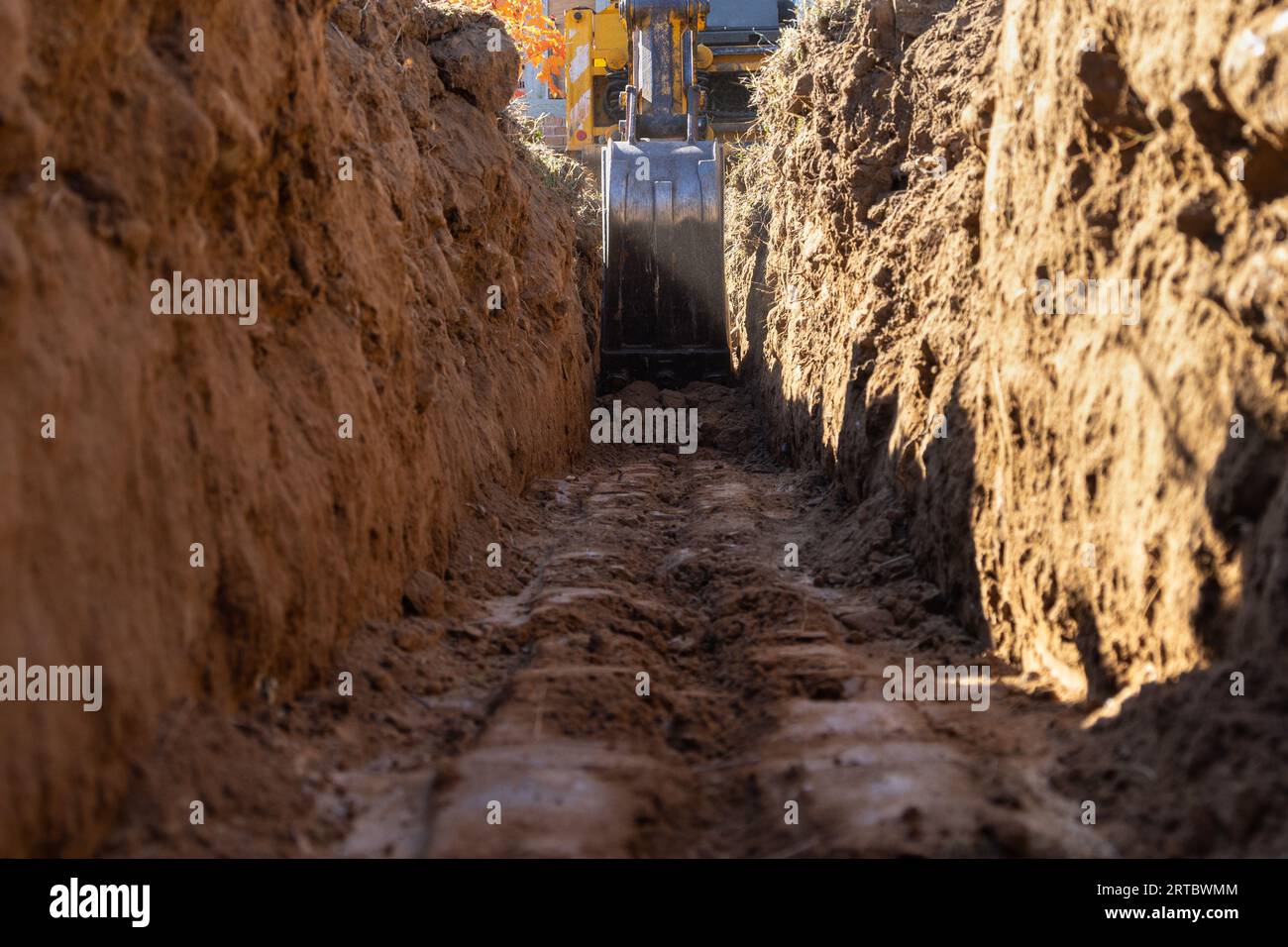 Bagger gräbt einen Graben für ein kleines Hausfundament Stockfoto