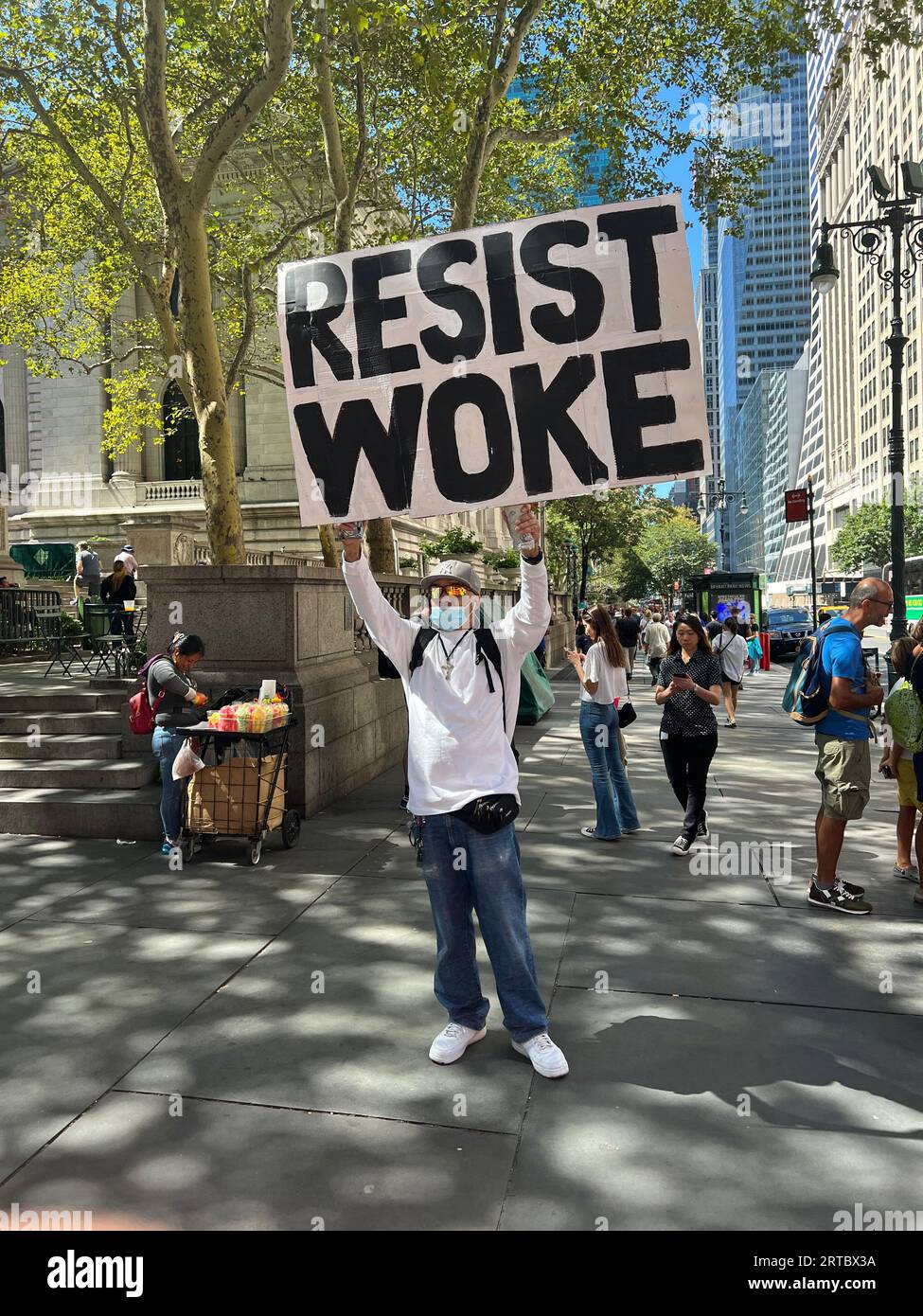 Mann mit einem großen Schild an der Ecke 5th Avenue und 42nd Street, spricht sich mutig gegen die sogenannte Wake Agenda aus, die er oft für unmoralisch und dämonisch hält, wie sie auf einer Seite seines Schildes steht. New York City. Stockfoto
