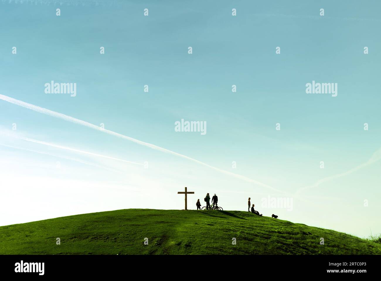 Menschen um das große Kreuz auf einem grünen Hügel Stockfoto