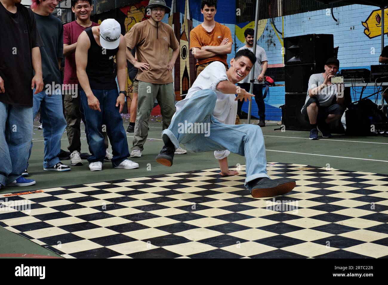 Ein großer männlicher Hip-Hop-Tänzer, der mit einer Handpflanze in eine Rutsche fällt, Street Breakdance-Auftritte, Wettkämpfe und Battles treten in die Fußarbeit Stockfoto