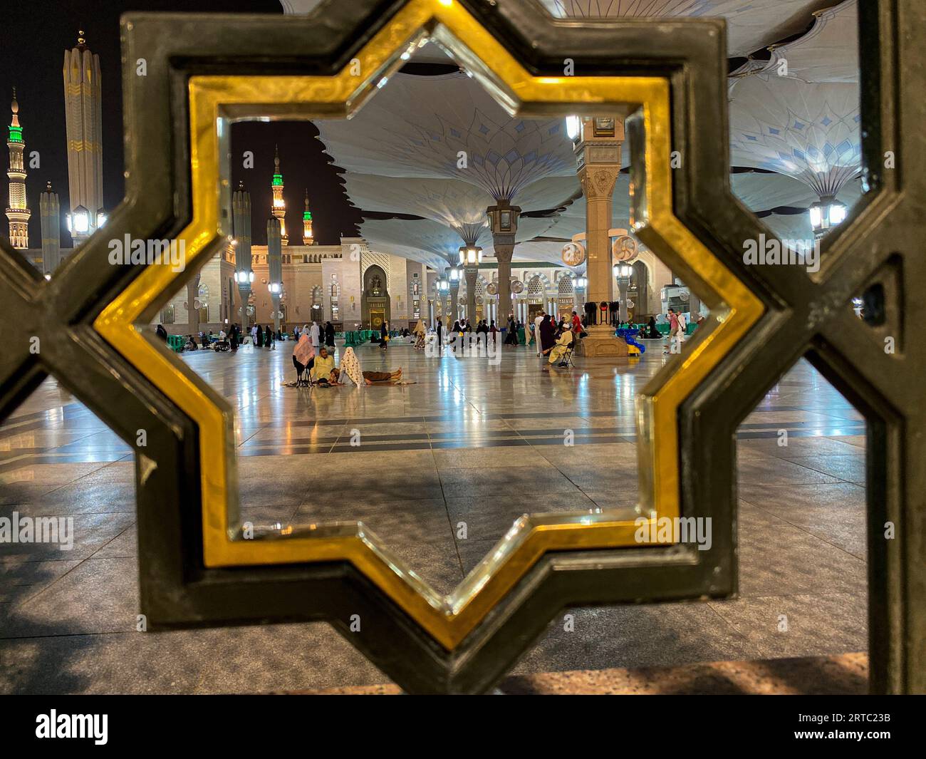 Medina, Saudi-Arabien - 22. August 2023: Pilger laufen unter riesigen Sonnenschirmen auf dem Gelände der Nabawi-Moschee. Baldachin bei Masjid Nabawi in Medina, Saudi-Arabien Stockfoto