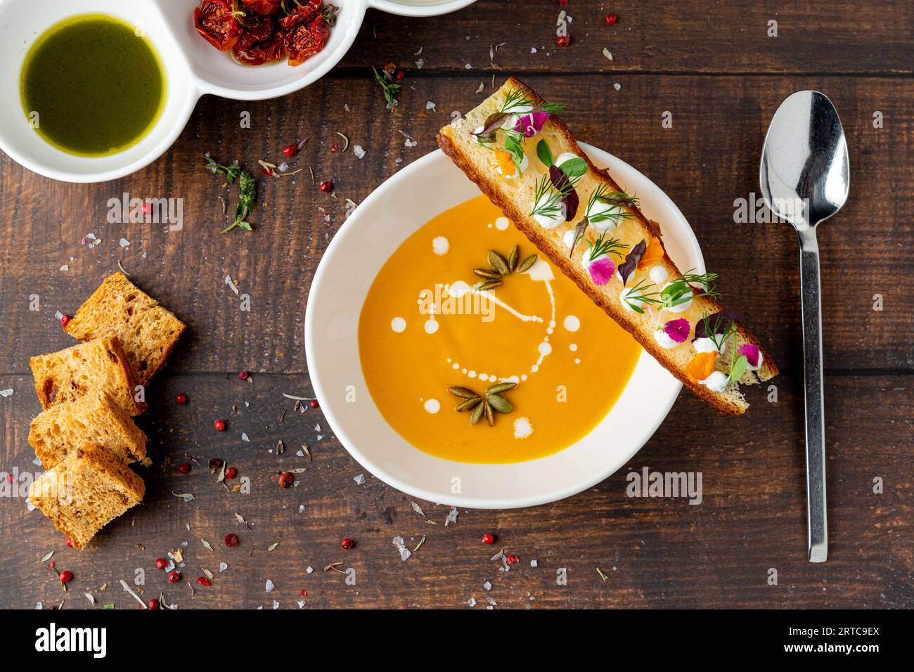 Italienische Kürbissuppe Zuppa di giornata auf weißem Porzellanteller auf Holztisch Stockfoto