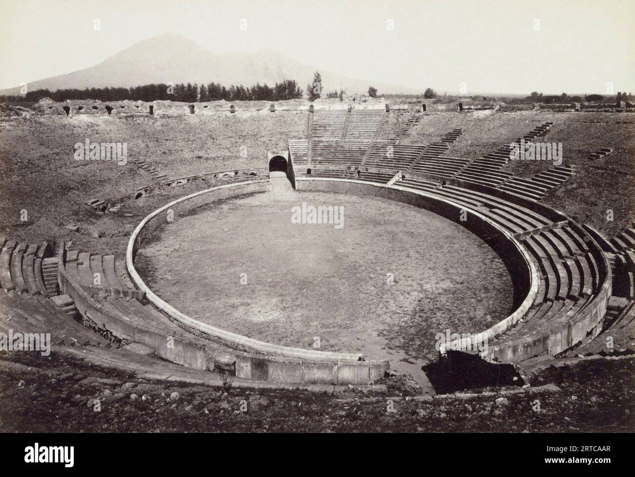 Archäologische Stätte Pompeji, Kampanien, Italien. Das ausgegrabene Amphitheater, wie es Ende des 19. Jahrhunderts war. Mt. Vesuv, der Vulkan, der die Stadt zerstörte, ist im Hintergrund zu sehen. Stockfoto