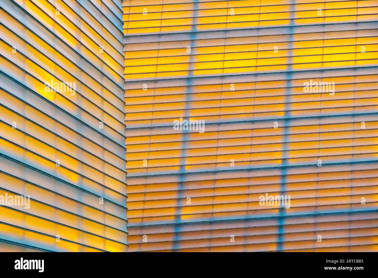 Hintergrund gelber symmetrischer Linien mit echter Beleuchtung an einer Wand Stockfoto