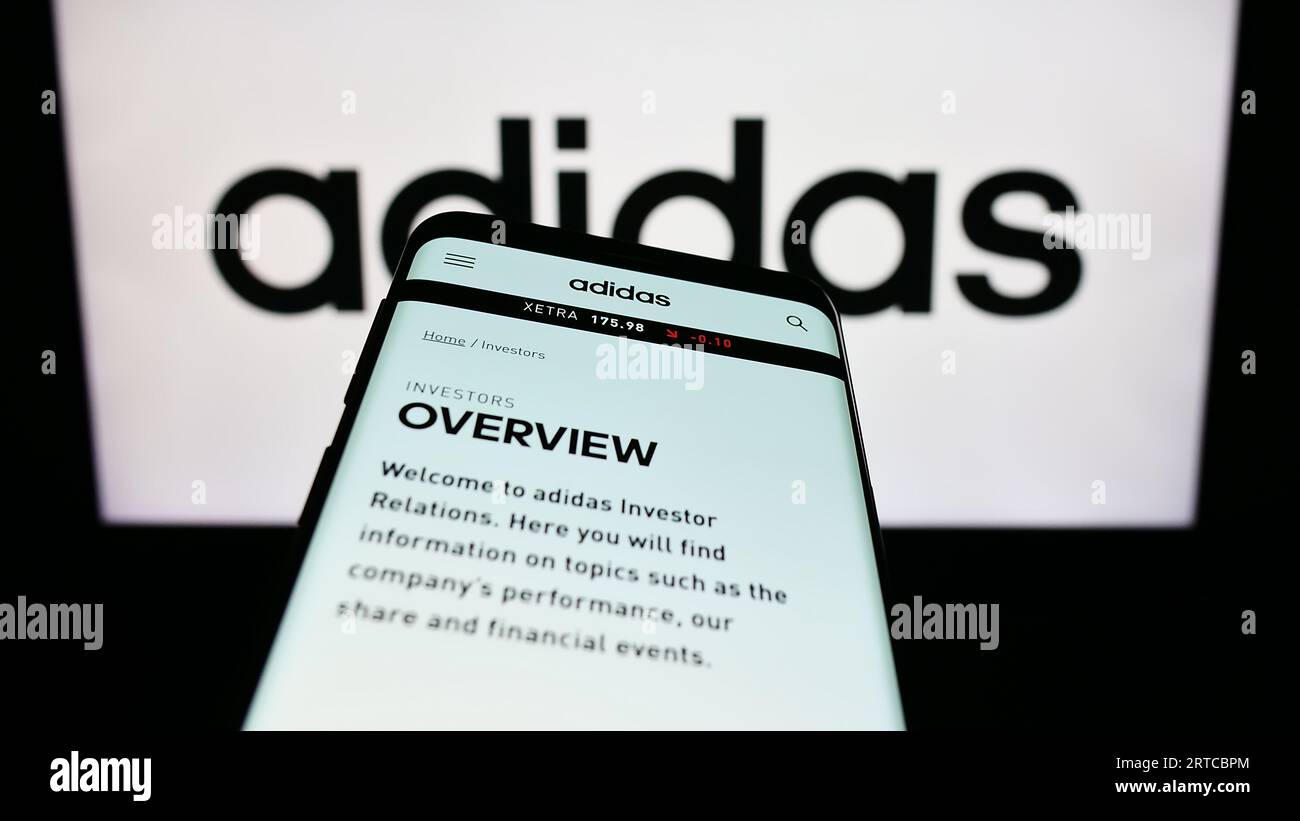 Smartphone mit Website des deutschen Bekleidungs- und Schuhherstellers Adidas AG auf dem Bildschirm vor dem Firmenlogo. Konzentrieren Sie sich auf die obere linke Ecke des Telefondisplays. Stockfoto