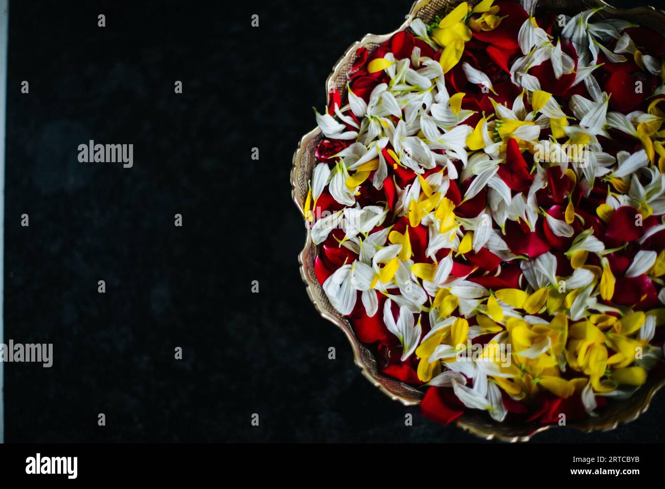 Pune, Indien, eine Schüssel mit Blütenblättern, Jasmin, Rose und Ringelblumen in einer Messingschale Stockfoto