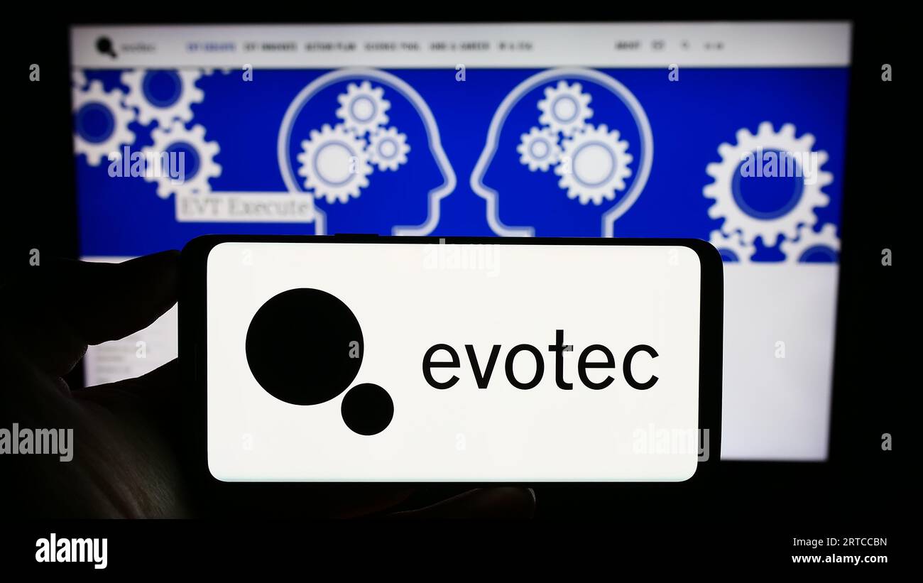 Person, die ein Mobiltelefon mit dem Logo des deutschen Arzneimittelforschungsunternehmens Evotec SE auf dem Bildschirm vor der Geschäftswebseite hält. Konzentrieren Sie sich auf das Display des Telefons. Stockfoto