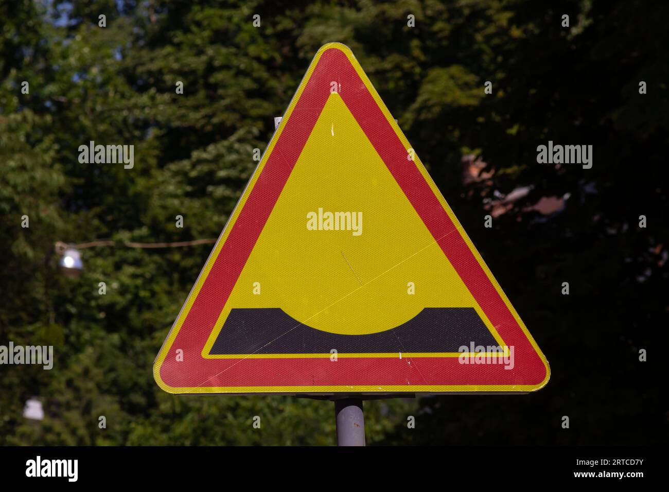 Ein dreieckiges Straßenschild, das auf das Vorhandensein von Unebenheiten hinweist. Stockfoto