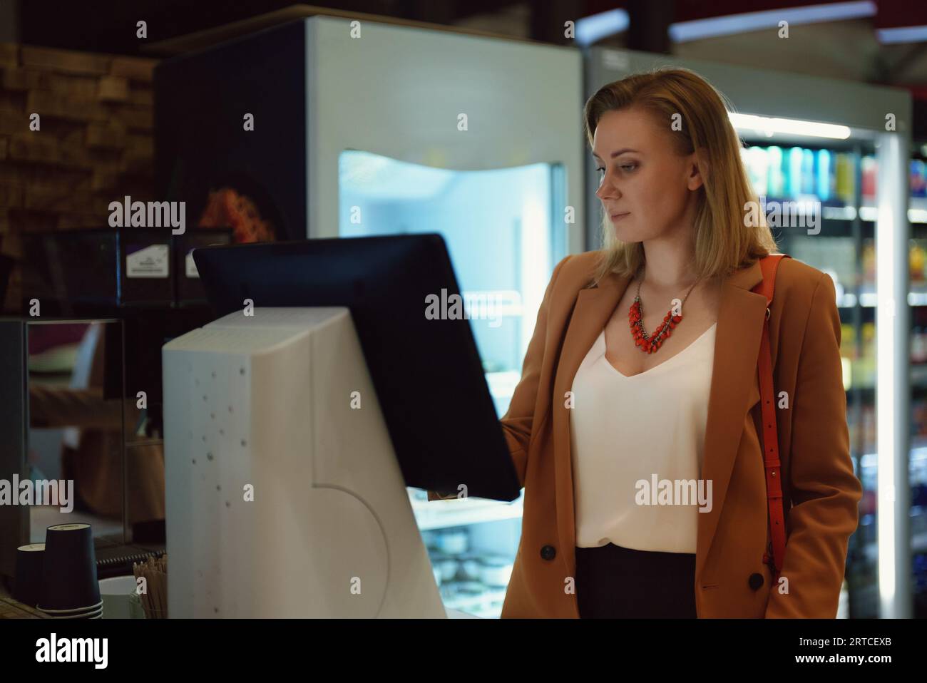 Frau zahlt an Selbstcheckouts im Supermarkt. Stockfoto