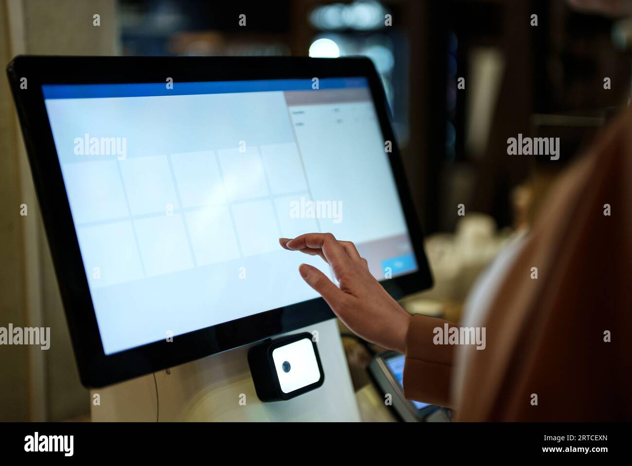 Frau zahlt an Selbstcheckouts im Supermarkt. Stockfoto