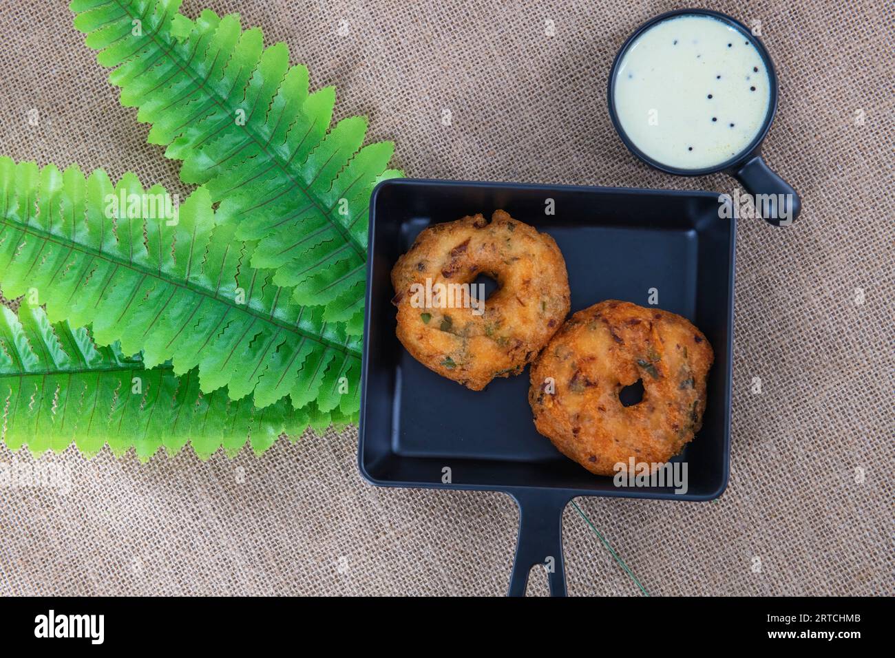 Indische traditionelle Snacks Medhu vadai, auch Ulunda vadai genannt. Berühmter Tamilnadu-Snack namens Medhu vada auf einem Teller, serviert mit Kokos-Chutney. Vada. Stockfoto