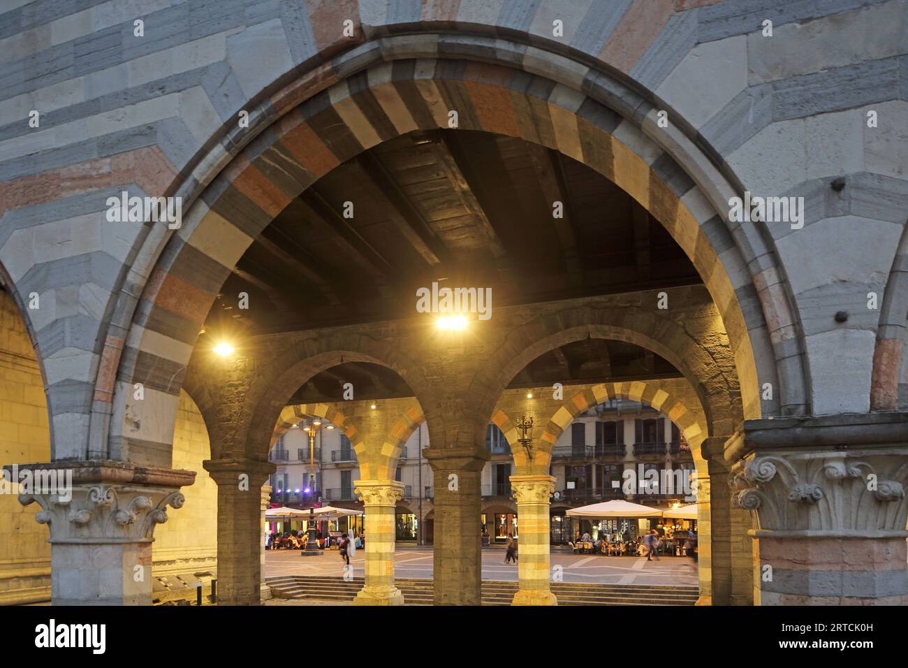 Blick durch die Arkaden des Broletto auf die Caféhausterrassen auf der Via Caio Plinio Secondo, Como, Comer See, Lombardei, Italien Stockfoto