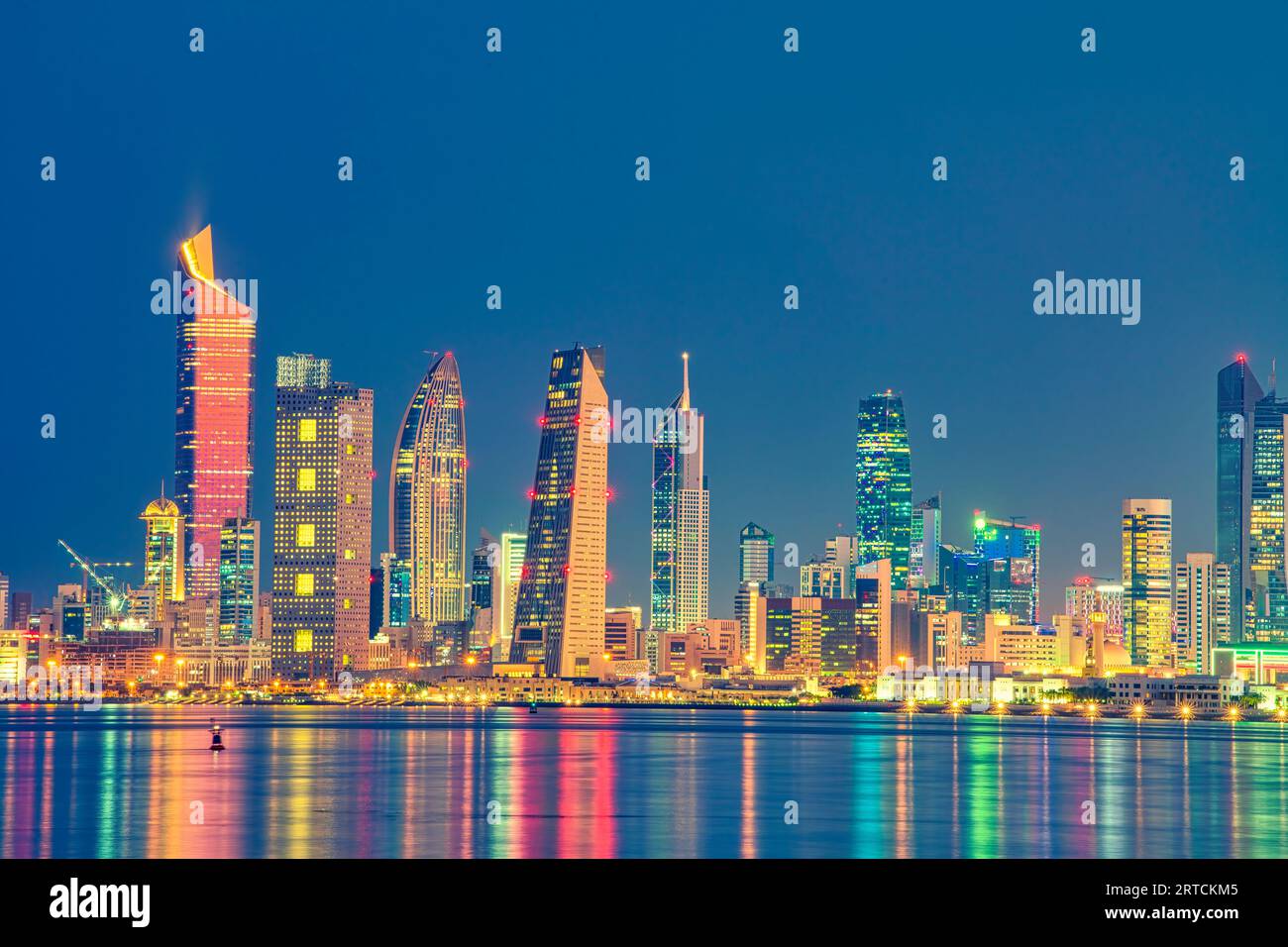 Blick auf die Skyline von Kuwait vom Strand aus während der Nationalfeiertage. Kuwait National Tageslichter auf dem Gebäude und Kuwait Flagge Lichter während der Nacht Stockfoto