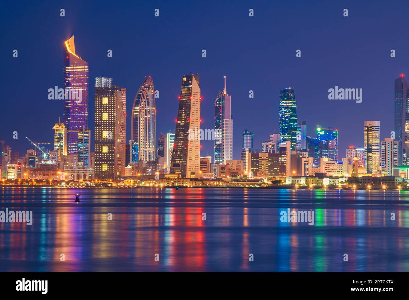 Blick auf die Skyline von Kuwait vom Strand aus während der Nationalfeiertage. Kuwait National Tageslichter auf dem Gebäude und Kuwait Flagge Lichter während der Nacht Stockfoto
